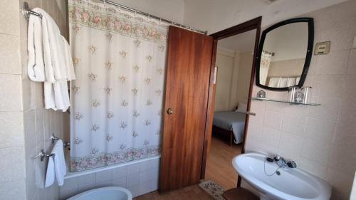 W łazience znajduje się umywalka, toaleta i lustro. w obiekcie Hotel Bela Vista w mieście Viseu