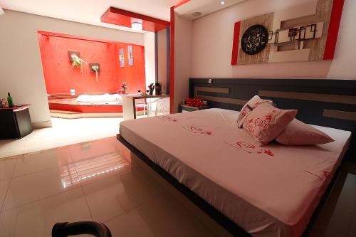a bedroom with a large bed and a bathroom at Motel Luxury in Votorantim