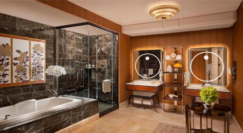a bathroom with a tub and a sink and mirror at Wynn Las Vegas in Las Vegas