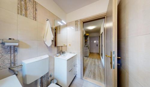 a white bathroom with a toilet and a sink at Apartman Tina in Metković