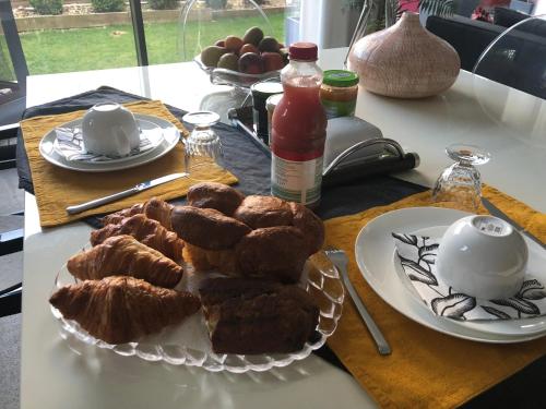 un tavolo con un piatto di prodotti da forno su un tavolo di Chambre hôtes nichée sous les toits a Rennes