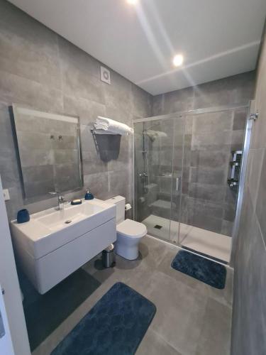 a bathroom with a sink and a shower and a toilet at A Casa da Areia Larga in Madalena