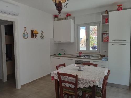 a kitchen with a table with chairs and a window at Residence LA VELA fronte mare in Montesilvano