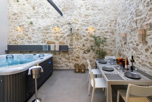 a bathroom with a sink and a table and a tub at VaSan suite in Rethymno