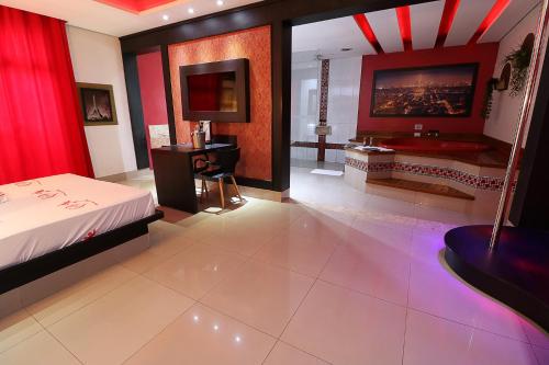 a bedroom with a bed and a bathroom with a tub at Motel Luxury in Votorantim