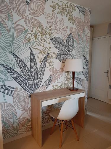 un bureau avec une lampe et une chaise dans une pièce dans l'établissement Appt cosy 65 m2 coeur de ville à 150 m de la plage, à Royan
