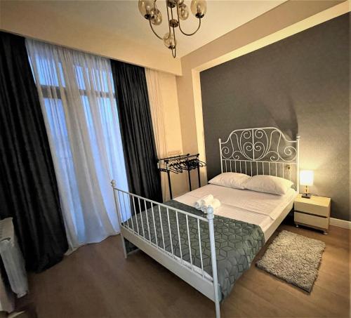 um quarto com uma cama com um berço de ferro forjado em Apartment D. Digomi em Tbilisi