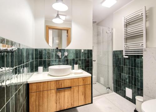 ein Bad mit einem Waschbecken und einem Spiegel in der Unterkunft Apartament Oliwkowy in Chmielno