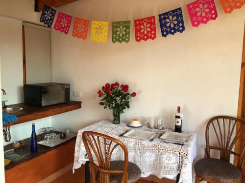 a dining room table with a vase of flowers on it at Titué Refugio , Cabañas in La Calera