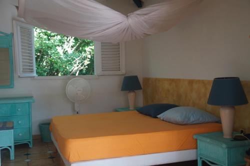 a bedroom with a bed and a window at Gîtes Mosaïques in Sainte-Rose