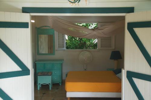 a small bedroom with a bed and a window at Gîtes Mosaïques in Sainte-Rose