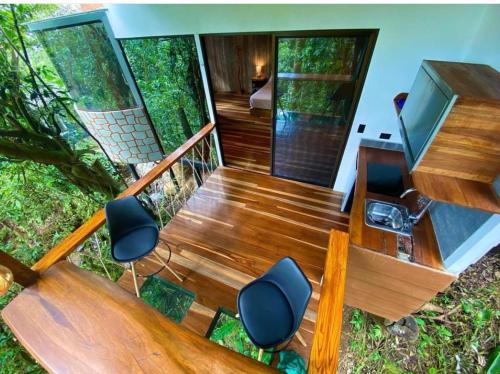 a wooden staircase with two chairs and a desk at Sweet Jungle in Quesada