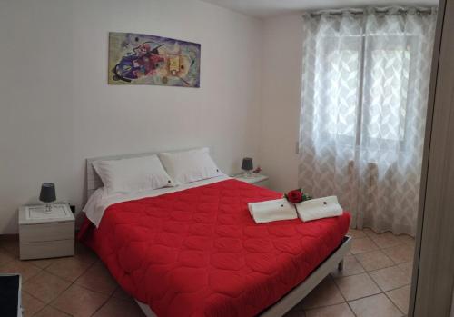 sypialnia z czerwonym łóżkiem i 2 ręcznikami w obiekcie Rosahouse w mieście Lecce