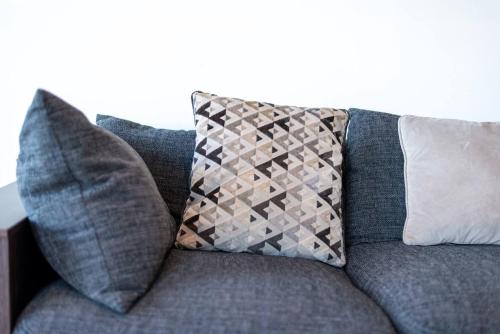 a blue couch with two pillows on it at Stunning Riverside View Apartment, near Canary Wharf & O2 in London