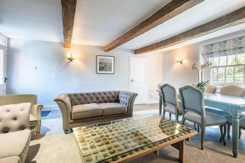 uma sala de estar com um sofá, uma mesa e cadeiras em The Aubrey - a gorgeous converted 17th Century Grade II listed bolthole in Bakewell em Bakewell