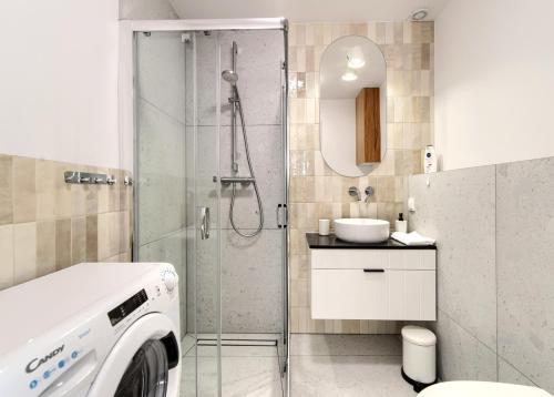 ein Bad mit einer Dusche und einer Waschmaschine in der Unterkunft Apartament Piaskowy in Chmielno