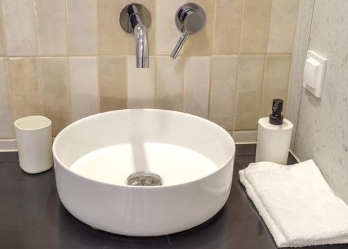 a white sink in a bathroom with aaucet at Apartament Piaskowy in Chmielno