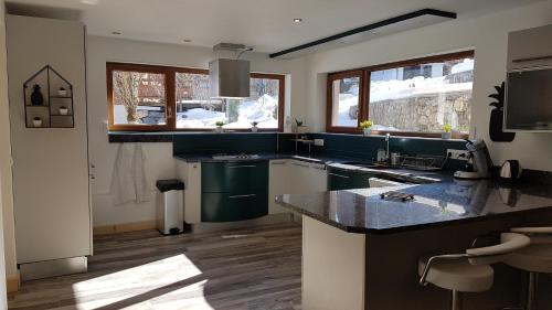 a kitchen with green cabinets and a counter top at Chalet les Vagnys - Lac des Vernays in La Rivière-Enverse