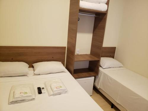 a small room with two beds and a mirror at Hotel Viracopos de Indaiatuba in Indaiatuba