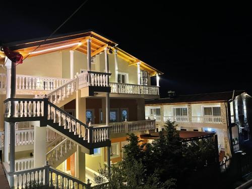 a large white building with balconies and stairs at night at Arial Penthouse Suites in Vlorë