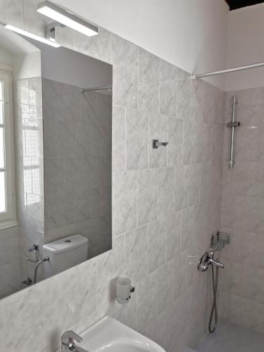 a bathroom with a sink and a mirror and a toilet at Spilia Apartments in Stavros