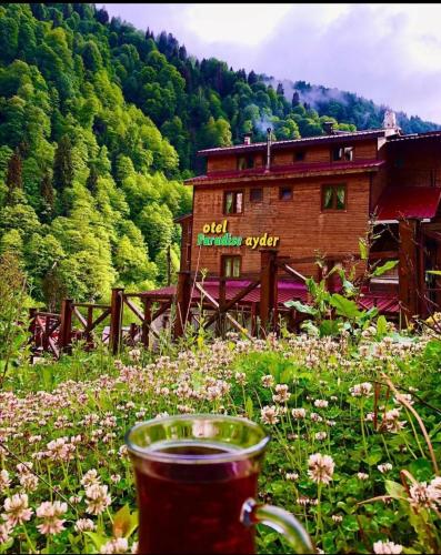 a building in the middle of a field of flowers at Ayder Paradise Otel in Ayder Yaylasi