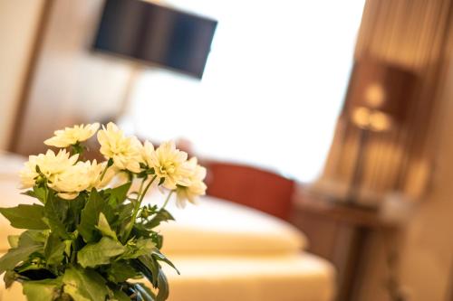 a vase filled with yellow flowers sitting on a table at Hotel Alpspitz B&B in Grainau