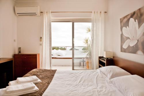 卡斯凱什的住宿－Luxury Sea View，一间卧室设有一张床和一个美景窗户。