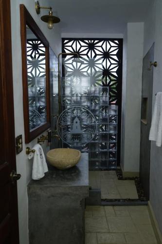 a bathroom with a sink and a glass wall at Honda Colonial Magdalena Resort in Honda
