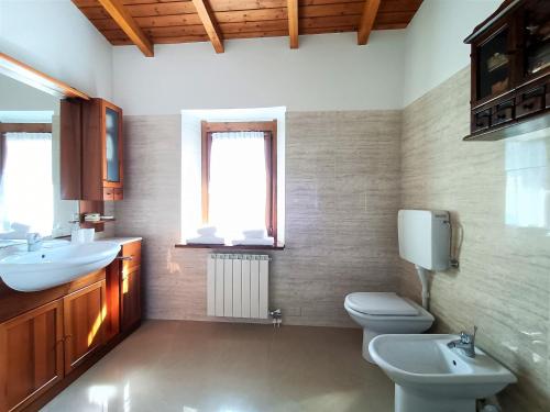 a bathroom with two sinks and a toilet and a window at IseoLakeRental - Chalet Giulia in Sovere