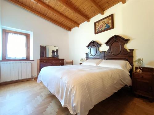 sypialnia z dużym łóżkiem z drewnianym zagłówkiem w obiekcie IseoLakeRental - Chalet Giulia w mieście Sovere