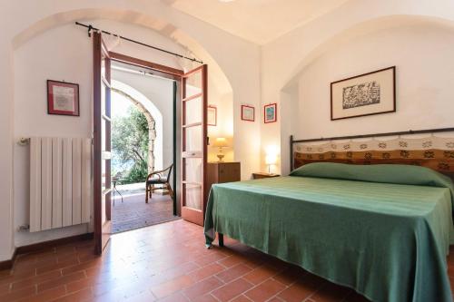 a bedroom with a green bed and an open door at Il Posto delle Fragole in Castro di Lecce