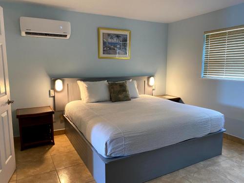 a bedroom with a large bed with two night stands at Hideaways Exuma in Georgetown