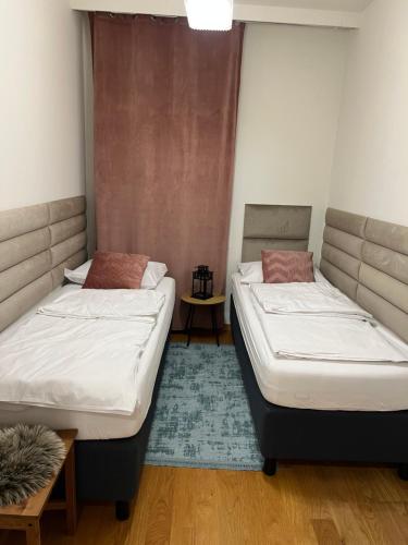 2 Betten in einem Zimmer mit einem Teppich in der Unterkunft Norblin Apart in Warschau