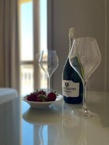 a bottle of wine and a plate of strawberries on a table at Terrazzo Del Borgo in Tropea