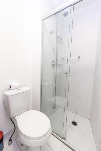 a white bathroom with a toilet and a shower at 360 Suítes Sé in Sao Paulo