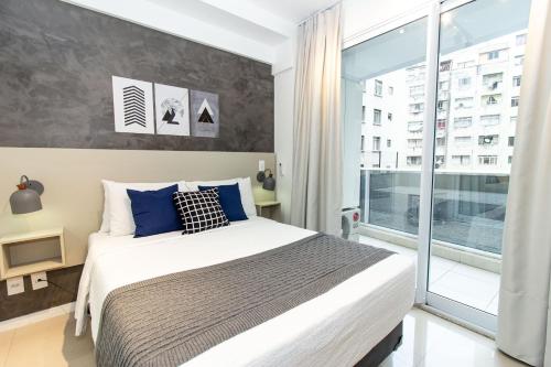 a bedroom with a large bed and a large window at 360 Suítes Sé in Sao Paulo