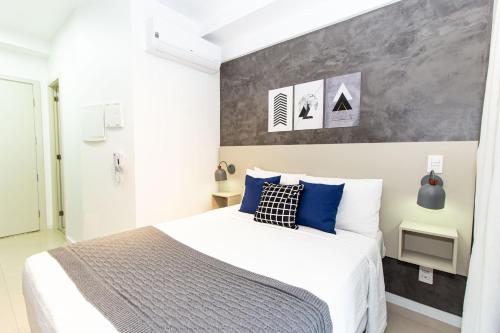 a bedroom with a large bed with blue pillows at 360 Suítes Sé in Sao Paulo