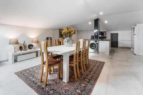 a kitchen and dining room with a white table and chairs at GuestReady - Crestuma Bright in Crestuma