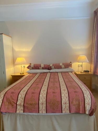 a bedroom with a large bed with two lamps at Landguard Lodge Guest House in Southampton
