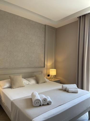 a bedroom with a large white bed with towels on it at Terrazzo Del Borgo in Tropea