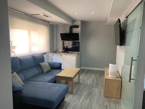 a living room with a blue couch and a table at Apartamentos Las 7 Esencias in Linares
