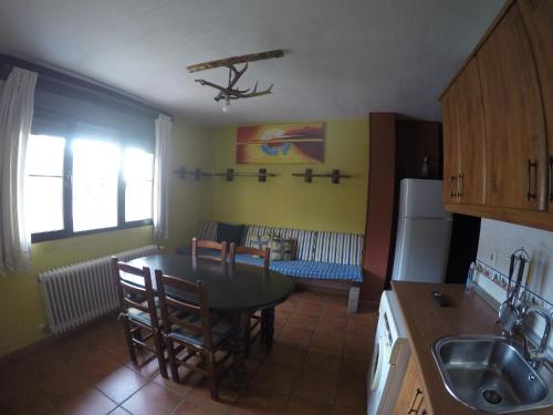 a kitchen with a table and chairs in a room at Fuente Del Gamellon in Buenache de la Sierra