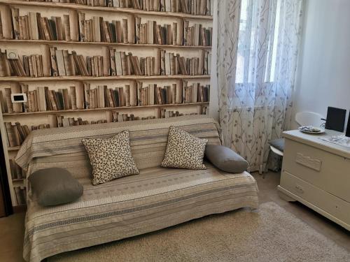a living room with a couch and a shelf of books at Appartamento Ca' Di Nive in Venice