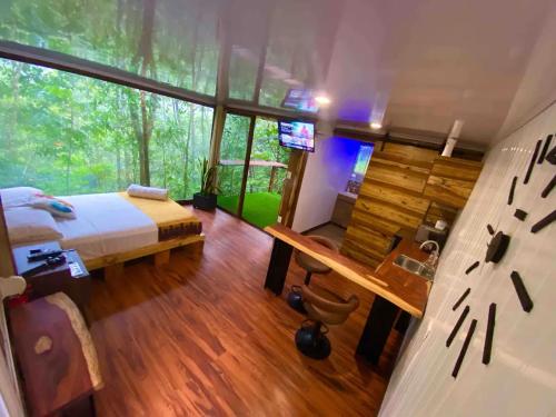 a bedroom with a bed and a desk and a television at Sweet Jungle in Quesada