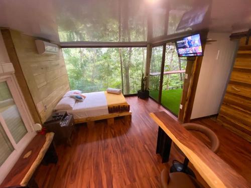 a bedroom in a tree house with a bed and a tv at Sweet Jungle in Quesada