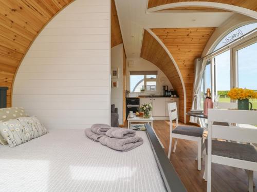 a bedroom in a tiny house with a bed and a kitchen at Buttercup in Hull