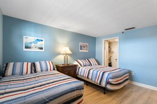 Duas camas num quarto com paredes azuis em 409 Beach Place Condos em St. Pete Beach