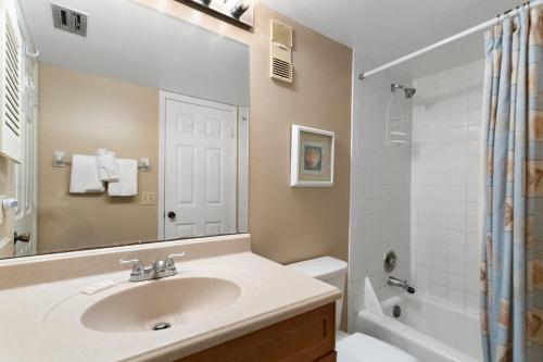 La salle de bains est pourvue d'un lavabo, de toilettes et d'une douche. dans l'établissement 409 Beach Place Condos, à St. Pete Beach