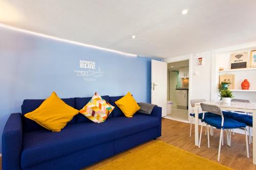 ポルトにあるOporto Blue Picaria - Unique Citycenter Apartmentの青いソファ(黄色の枕付)が備わるリビングルーム